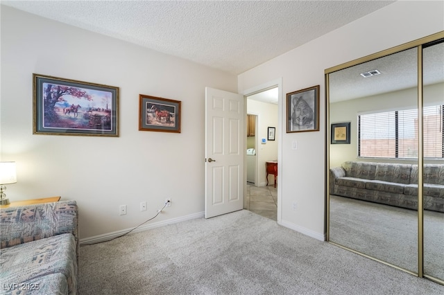 carpeted living area featuring a textured ceiling and baseboards