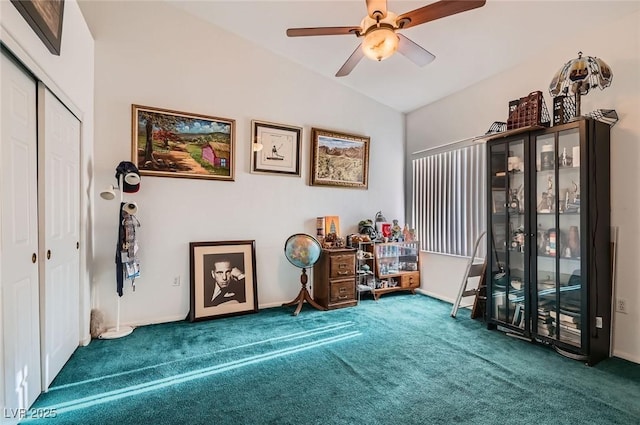 interior space featuring ceiling fan, carpet floors, vaulted ceiling, and baseboards
