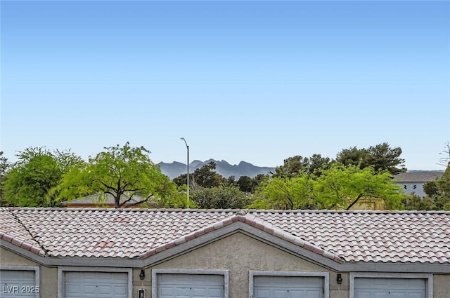 exterior space featuring a tiled roof, stucco siding, and a mountain view