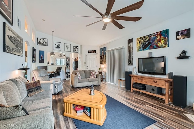 living room featuring vaulted ceiling, wood finished floors, visible vents, arched walkways, and ceiling fan
