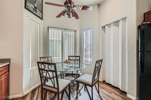 dining space featuring ceiling fan, baseboards, and wood finished floors