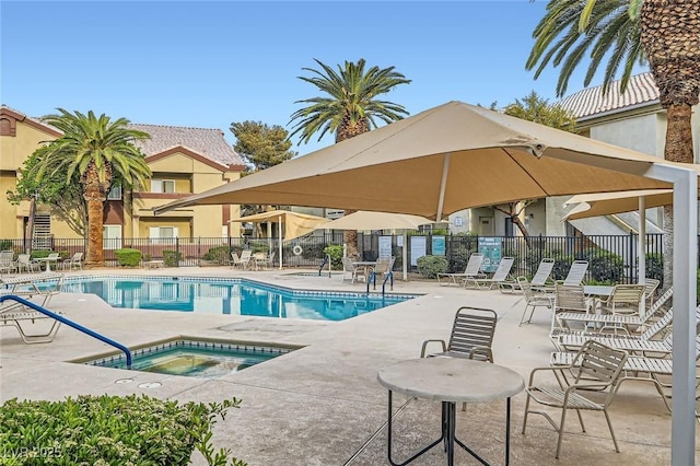 pool with fence, a patio area, and a hot tub