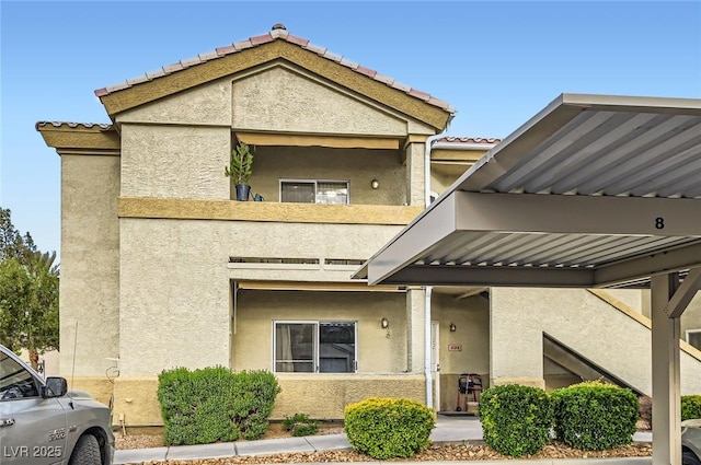 multi unit property with a balcony and stucco siding