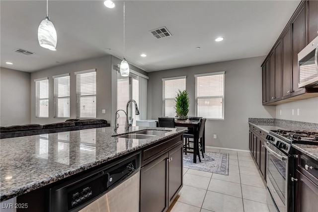 kitchen featuring dark brown cabinetry, stainless steel appliances, visible vents, and a sink