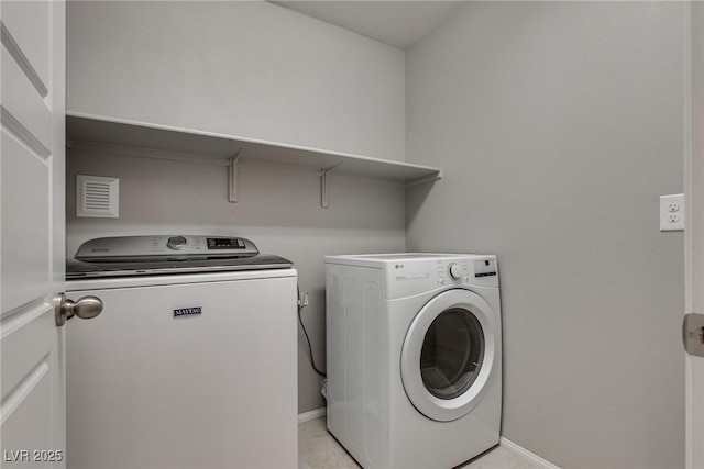 laundry area featuring visible vents, washing machine and clothes dryer, baseboards, and laundry area