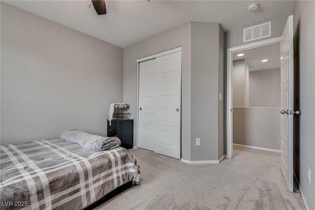 carpeted bedroom with a closet, visible vents, a ceiling fan, and baseboards
