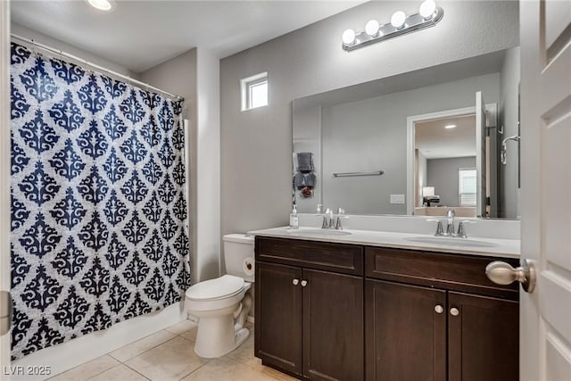 full bathroom with double vanity, tile patterned floors, toilet, and a sink