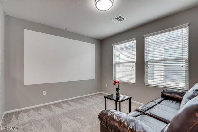 living room with visible vents, baseboards, and light carpet