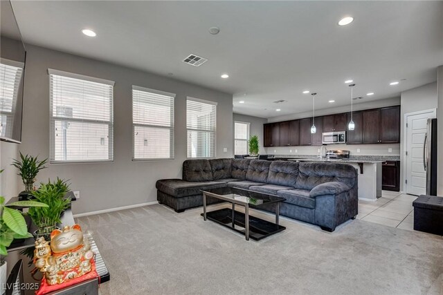living area featuring light colored carpet, baseboards, visible vents, and recessed lighting