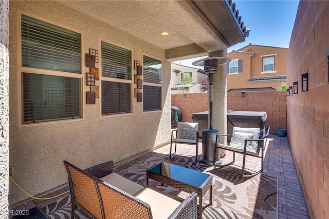 view of patio / terrace with fence and a hot tub