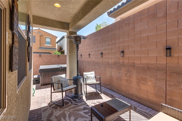 view of patio / terrace with a fenced backyard and a hot tub