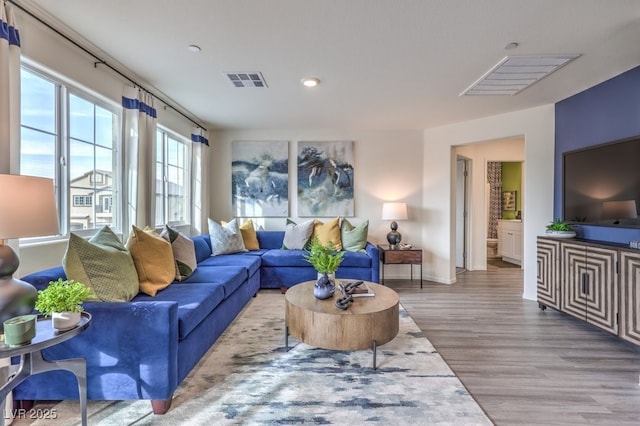 living room featuring baseboards, wood finished floors, visible vents, and recessed lighting