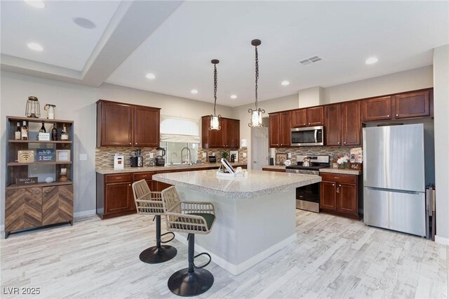 5409 Holding Ave, Las Vegas, NV 89139 - kitchen featuring a sink, stainless steel appliances, light wood finished floors, backsplash, and visible vents