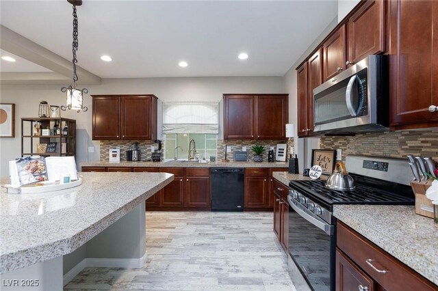 5409 Holding Ave, Las Vegas, NV 89139 - kitchen featuring a sink, decorative backsplash, stainless steel appliances, light wood-style flooring, and decorative light fixtures
