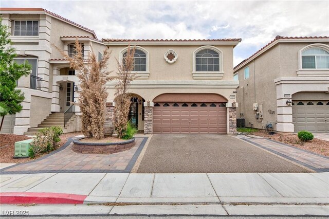 5409 Holding Ave, Las Vegas, NV 89139 - mediterranean / spanish house with a tile roof, driveway, stone siding, a garage, and stucco siding