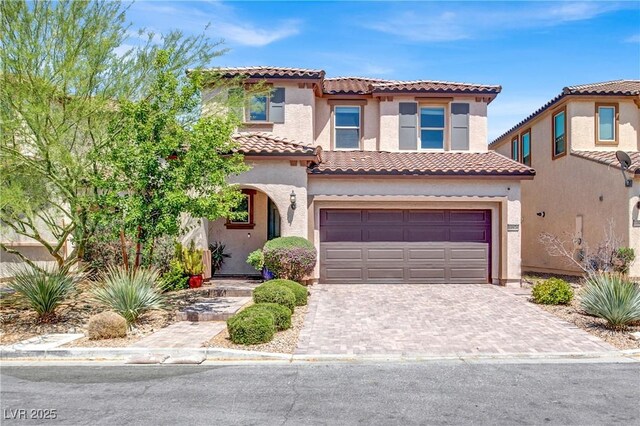 10976 Bluebell Basin Rd, Las Vegas, NV 89179 - mediterranean / spanish-style house featuring a tiled roof, an attached garage, decorative driveway, and stucco siding
