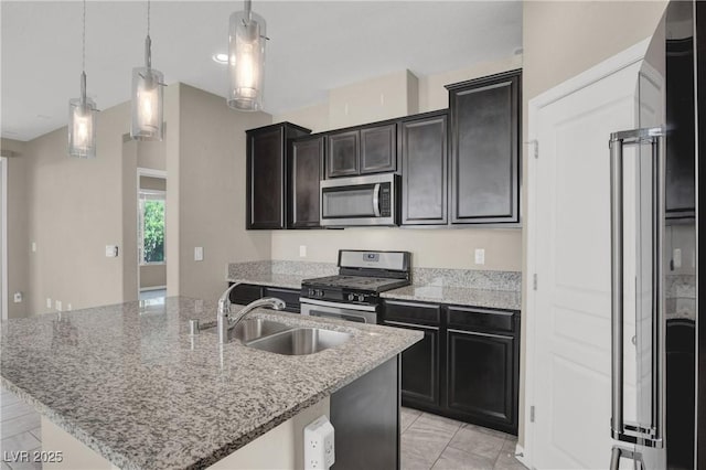 10976 Bluebell Basin Rd, Las Vegas, NV 89179 - kitchen featuring appliances with stainless steel finishes, a sink, an island with sink, light stone countertops, and hanging light fixtures