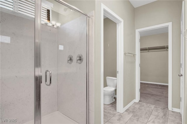 10976 Bluebell Basin Rd, Las Vegas, NV 89179 - bathroom with toilet, a stall shower, a walk in closet, baseboards, and marble look tiles