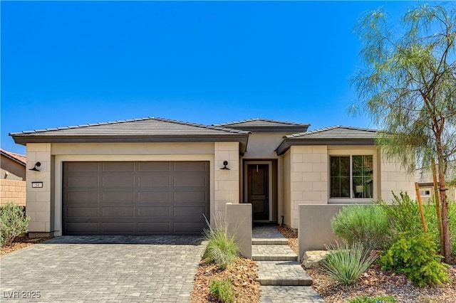 54 Mirage View Dr, Henderson, NV 89011 - view of front of home with an attached garage, decorative driveway, a tiled roof, and concrete block siding