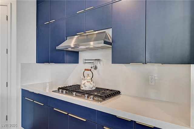 54 Mirage View Dr, Henderson, NV 89011 - kitchen featuring blue cabinetry, under cabinet range hood, stainless steel gas stovetop, and light countertops
