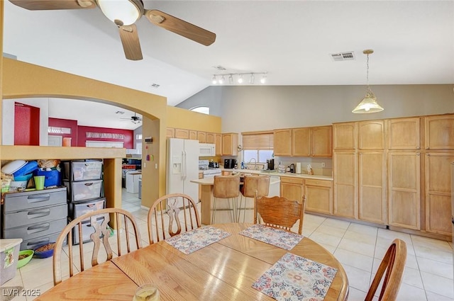 dining space with track lighting, visible vents, light tile patterned flooring, high vaulted ceiling, and ceiling fan