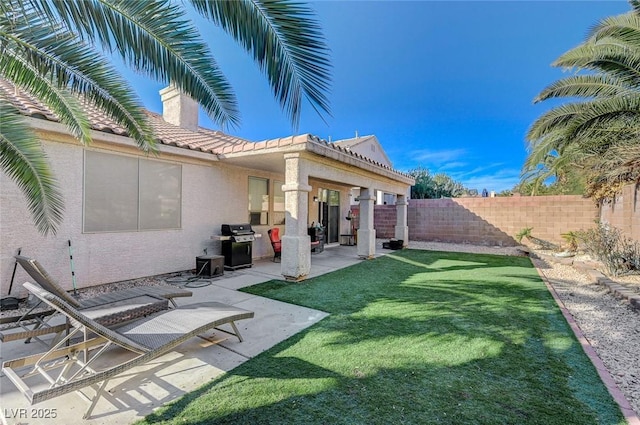 exterior space with a chimney, a tiled roof, a fenced backyard, a patio, and stucco siding