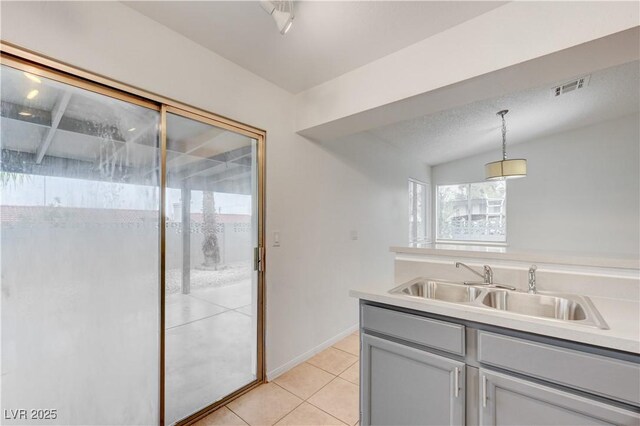 2377 Los Feliz St, Las Vegas, NV 89156 - kitchen with light tile patterned floors, hanging light fixtures, visible vents, a sink, and light countertops