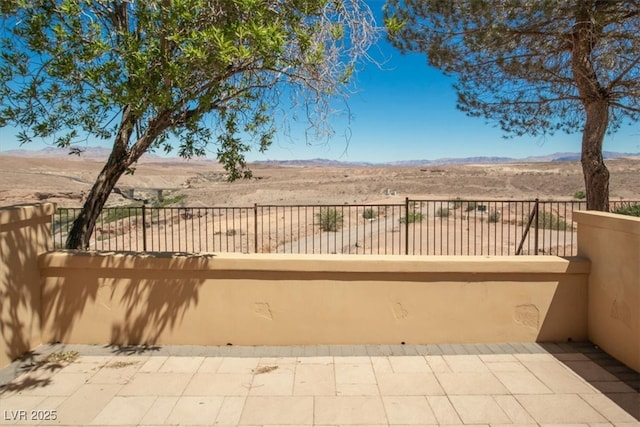 view of patio / terrace featuring fence, a balcony, and a mountain view