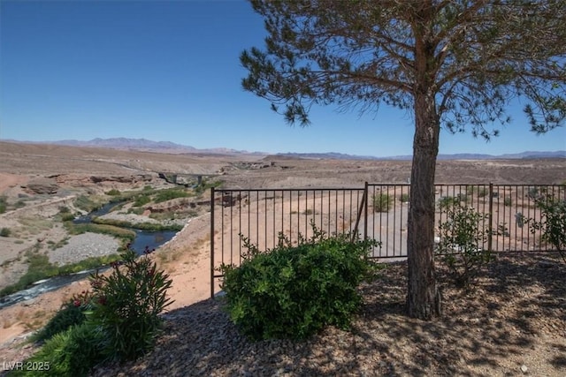 view of yard featuring fence and a mountain view