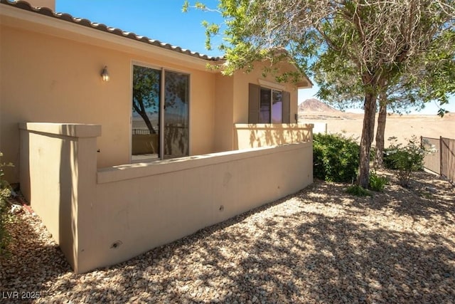 view of property exterior with fence and stucco siding