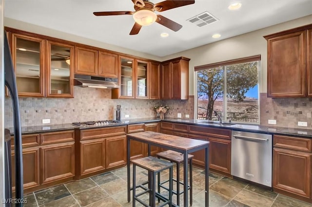 kitchen featuring dark countertops, under cabinet range hood, stainless steel appliances, and visible vents