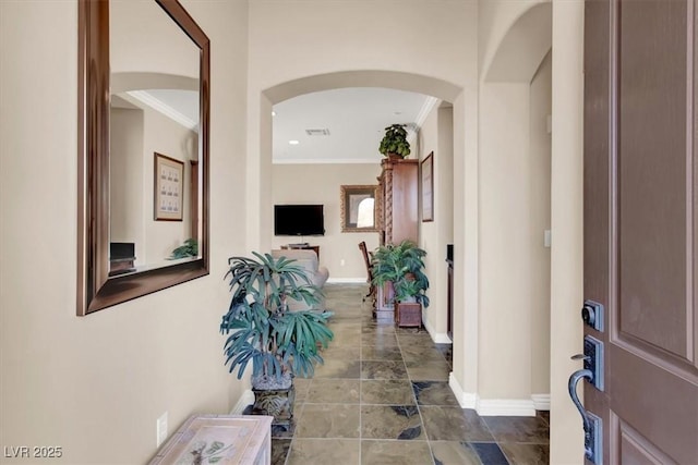 entryway featuring visible vents, baseboards, arched walkways, and crown molding