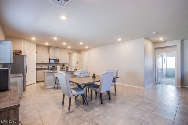 dining area featuring baseboards, light tile patterned flooring, visible vents, and recessed lighting