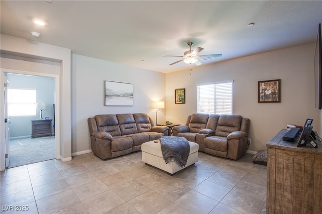 living room featuring baseboards, ceiling fan, and light tile patterned floors