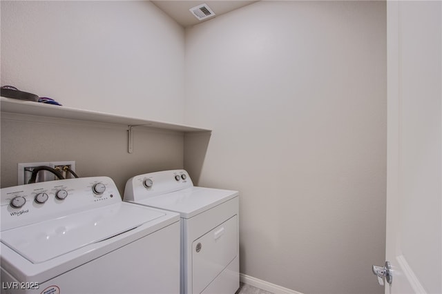 clothes washing area featuring washing machine and clothes dryer, visible vents, laundry area, and baseboards