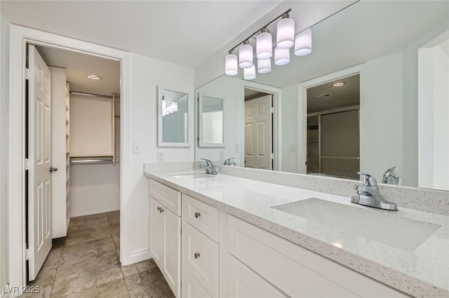 bathroom with baseboards, a sink, and double vanity