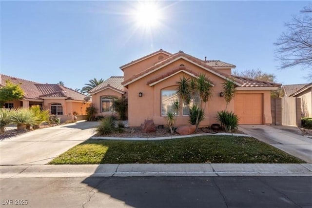 view of front of home featuring stucco siding, a tile roof, driveway, and an attached garage