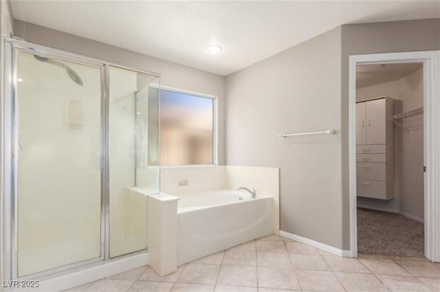 bathroom featuring a shower stall, baseboards, a bath, and tile patterned floors