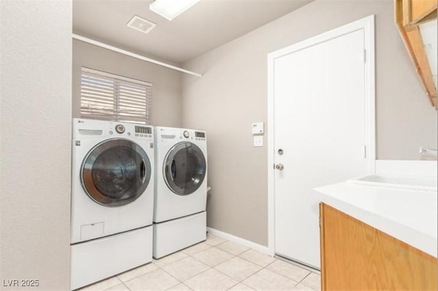 laundry room with visible vents, light tile patterned floors, baseboards, washer and dryer, and cabinet space