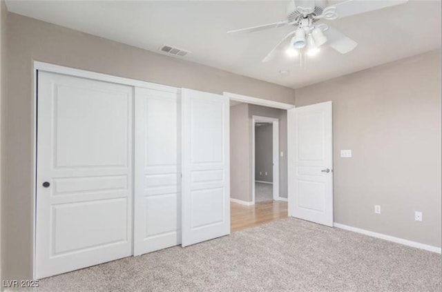 unfurnished bedroom with light carpet, baseboards, visible vents, a closet, and ceiling fan