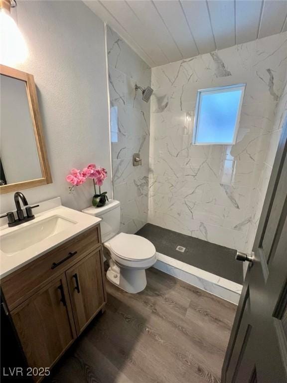 full bath featuring wood finished floors, a marble finish shower, vanity, wooden ceiling, and toilet