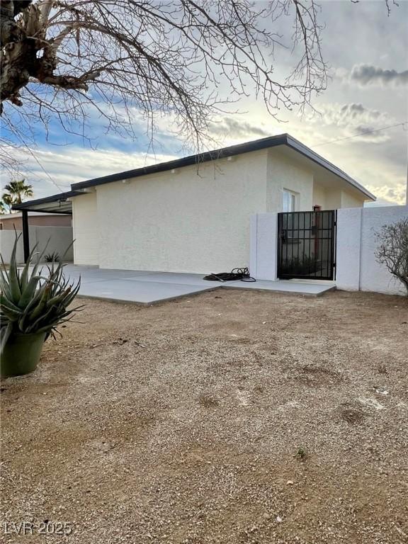exterior space with stucco siding and fence