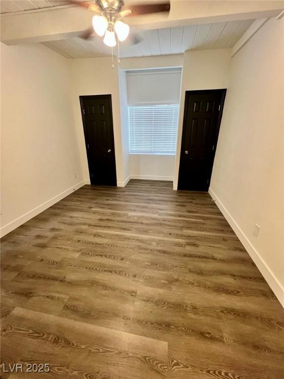 spare room with beamed ceiling, wooden ceiling, ceiling fan, and dark wood-style flooring