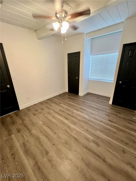 unfurnished bedroom featuring wood finished floors, baseboards, and ceiling fan