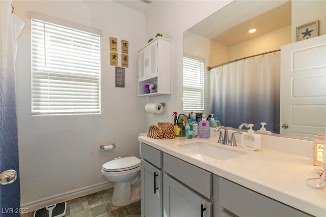 bathroom featuring toilet, vanity, curtained shower, and baseboards