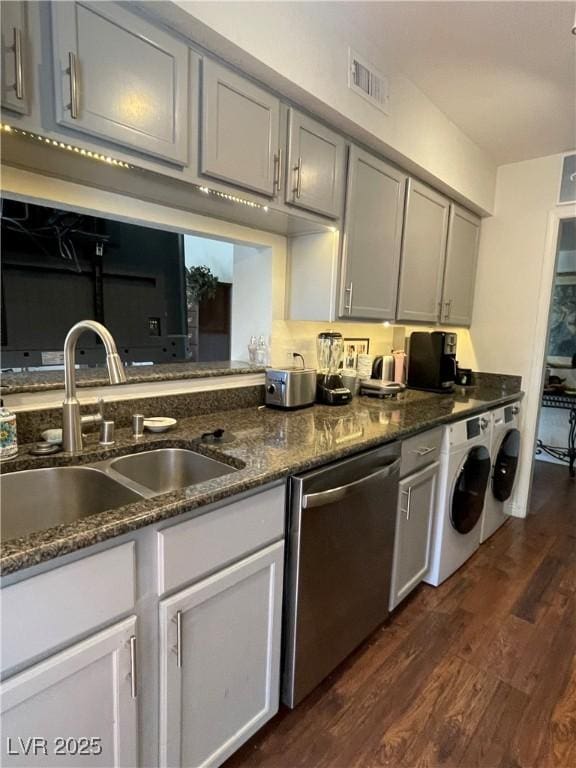 682 Oakmont Ave Unit 1507, Las Vegas, NV 89109 - kitchen featuring stainless steel dishwasher, separate washer and dryer, dark wood-style flooring, and dark stone countertops