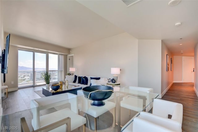 dining space with baseboards, wood finished floors, and visible vents