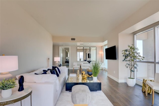 living area with baseboards, wood finished floors, and visible vents