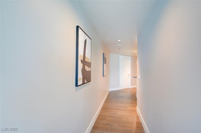 corridor featuring recessed lighting, baseboards, and light wood-style floors