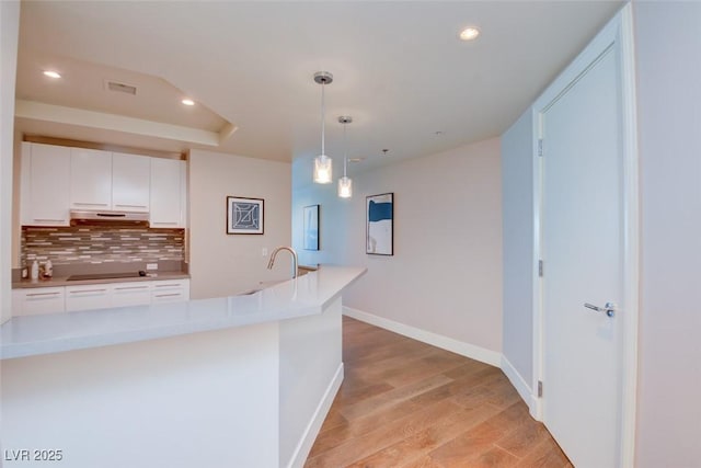 kitchen with baseboards, recessed lighting, light countertops, white cabinetry, and backsplash